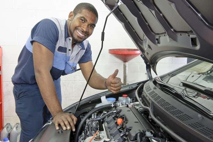 Auto technician inspecting car