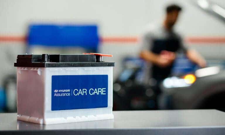 Hyundai car battery on table with shop in background