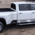 A white Silverado 3500 is parked at a worksite. parked