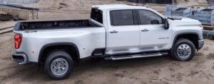 A white Silverado 3500 is parked at a worksite. parked