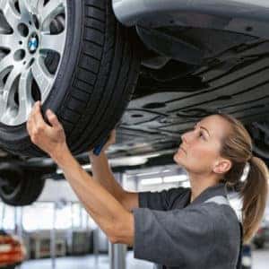 Service woman completing a tire alignment.
