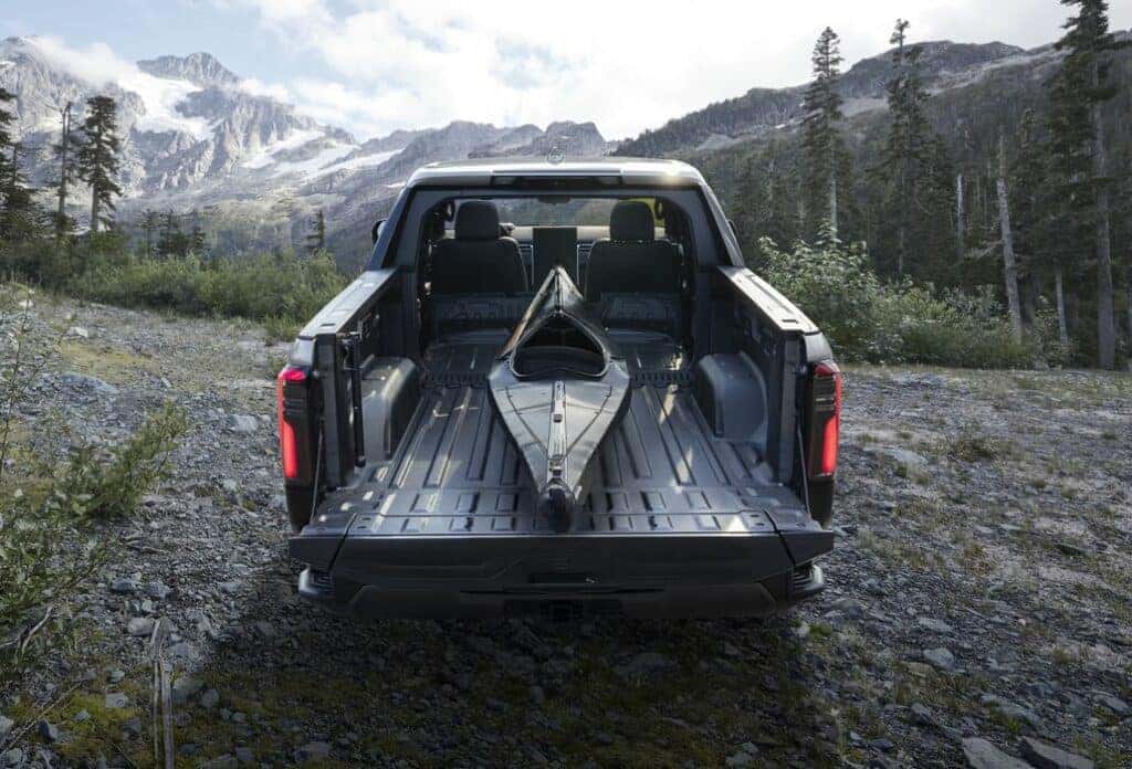 2024 GMC Sierra Denali Ultimate 1500 Crew Cab Short Box in Titanium Rush Metallic, showing CarbonPro Bed and MultiPro Tailgate; rear view.