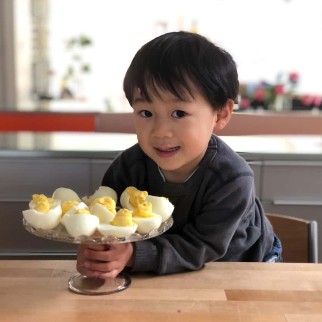 An Adorable Child Holding A Tray Of Hard-Boiled Eggs, A Healthy Snack For Your Kids