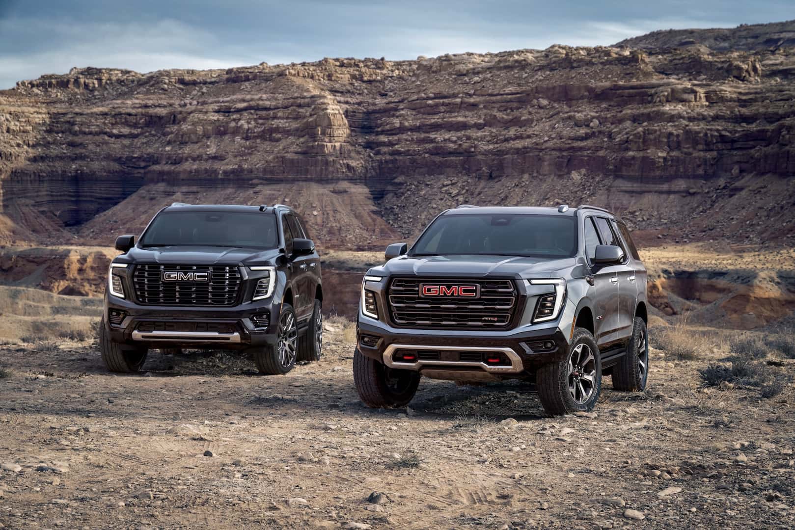 Pack view of the 2025 GMC Yukon, including the AT4 Ultimate (right) and Denali Ultimate (left).