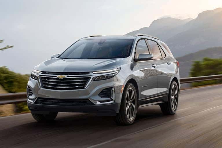 2023 Silver Chevrolet Equinox on a mountain road at sunrise