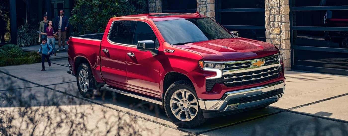 A red 2023 Chevy Silverado 1500 LTZ Z71 parked in a driveway by family.