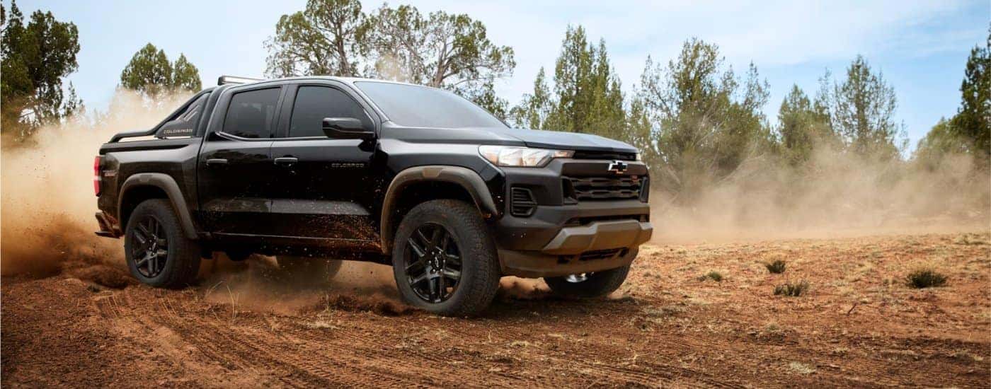 Black 2025 Chevy Colorado Trail Boss kicking up dust off-road