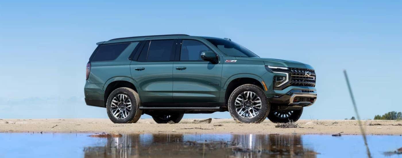 A green 2025 Chevy Tahoe Z71 shown parked on a beach.