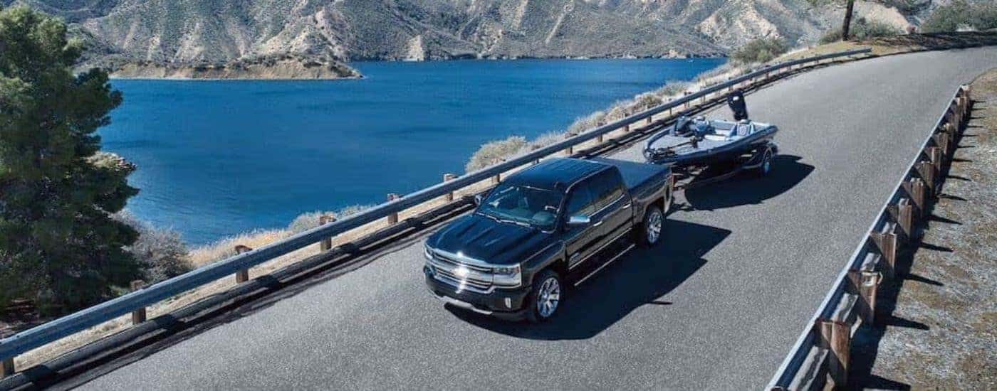 A black 2018 Chevy Silverado 1500 High Country is shown from a high angle towing a boat.