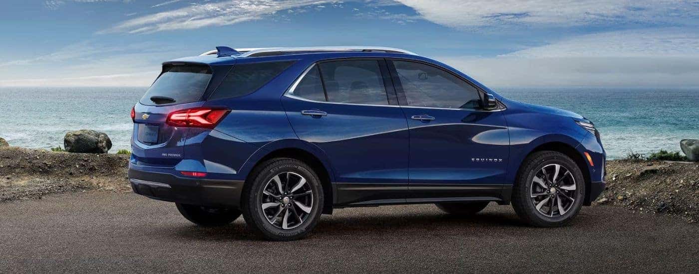 A blue 2023 Chevy Equinox parked by the ocean.