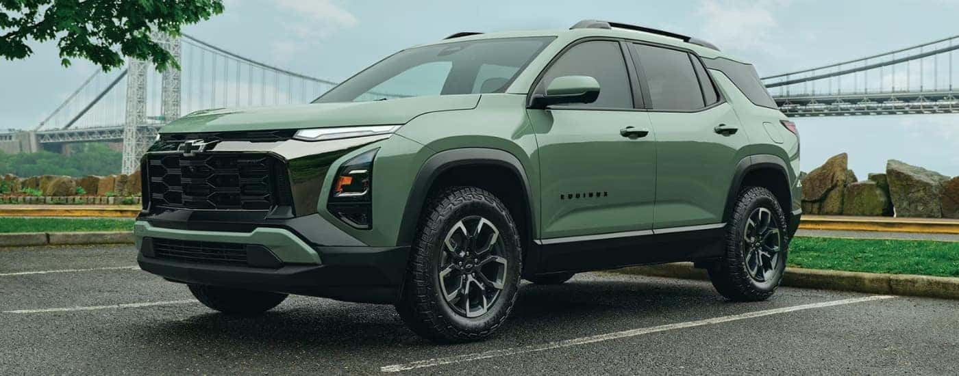 A green 2026 Chevy Equinox ACTIV parked near a bridge.