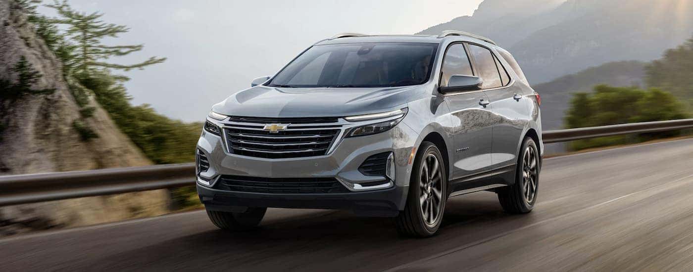 A silver 2023 Chevy Equinox driving on a highway.