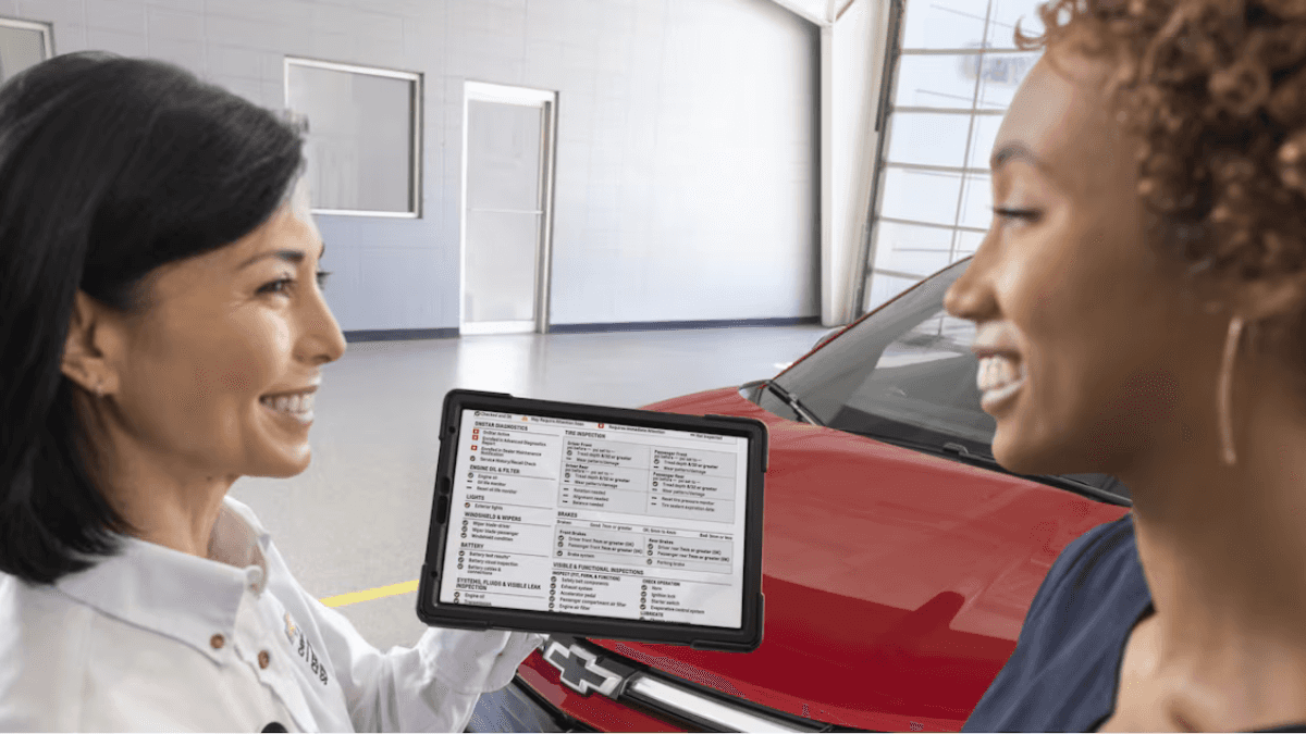 Service advisor or technician with a Chevy in the service bay