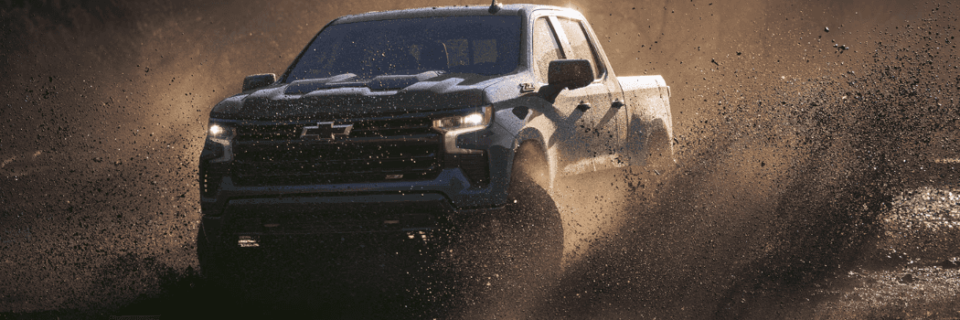 2026 Chevrolet Silverado driving through mud during an off-road adventure