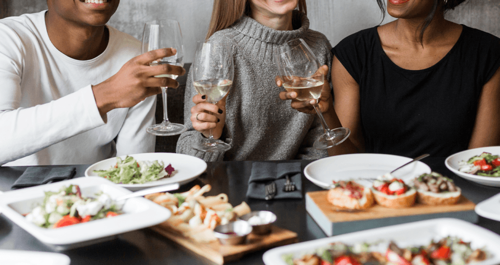 Chevy Dealer near Pittsburgh | Group of friends eating dinner with glasses of wine