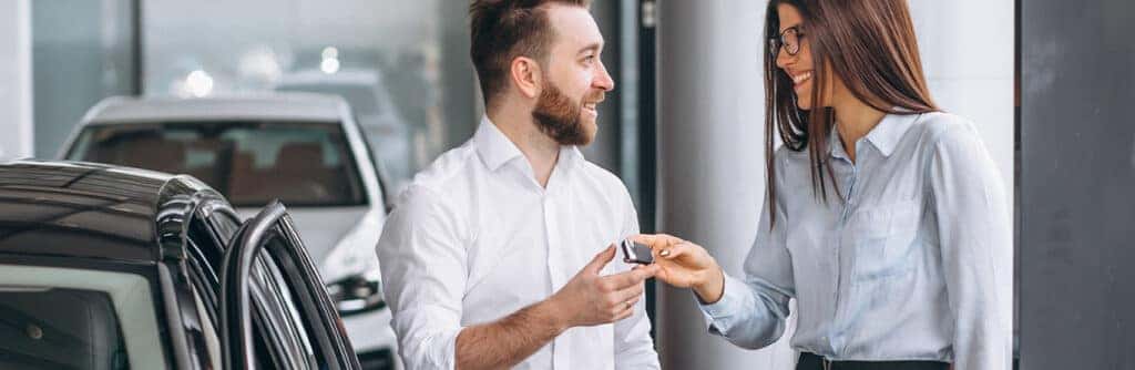 When to Trade In Your Car | Delaney Chevrolet of Greensburg in Greensburg, PA | Sales person handing over new car keys to customer