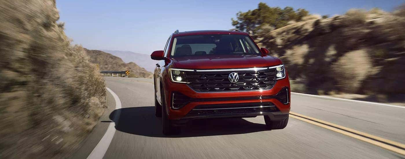 A red 2025 Volkswagen Atlas driving down a highway