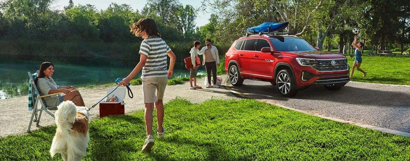 A red 2025 Volkswagen Atlas SEL Premium R-Line at a park.