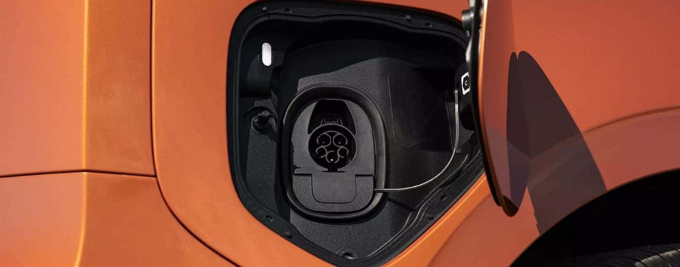 Charging port on an orange 2025 Volkswagen ID.Buzz.