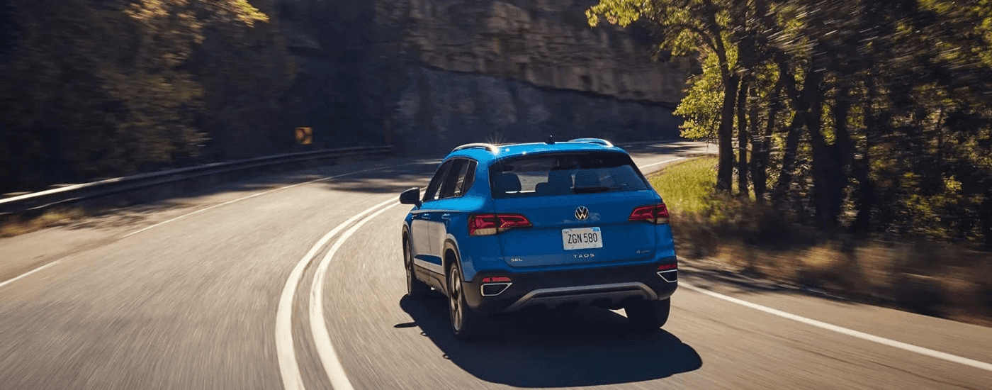 A blue 2024 Volkswagen Taos SEL rounding a corner.