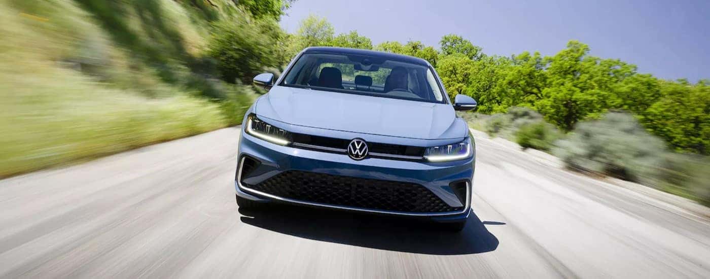 A blue 2025 Volkswagen Jetta driving on a highway.