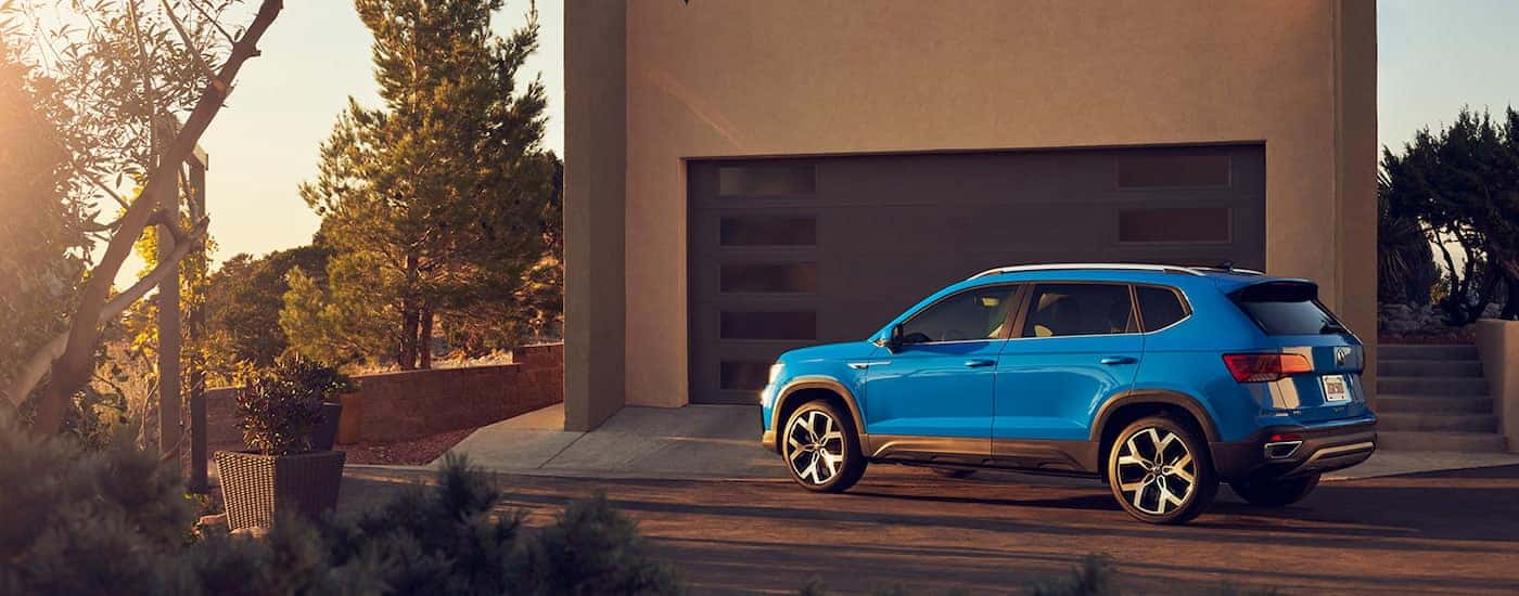 Blue 2022 Volkswagen Taos parked in front of a house