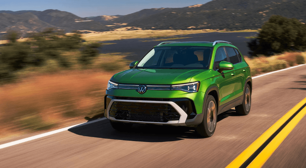 Green 2026 Volkswagen Taos driving to a Volkswagen dealer near Carpentersville