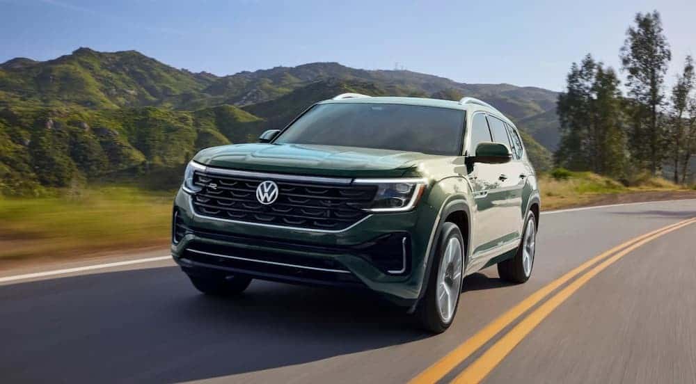 A green 2026 Volkswagen Atlas driving on a highway.