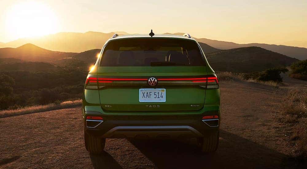 Rear view of a green 2026 Volkswagen Taos parked off-road