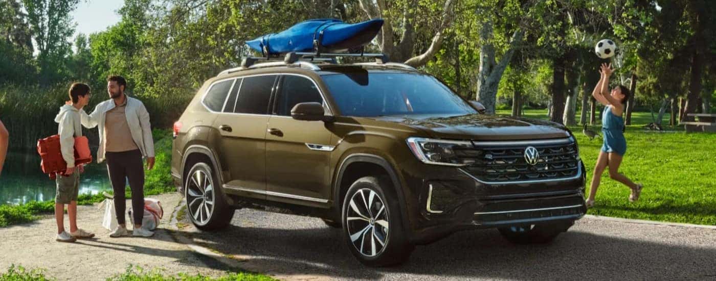 A green 2026 Volkswagen Atlas parked near a family.