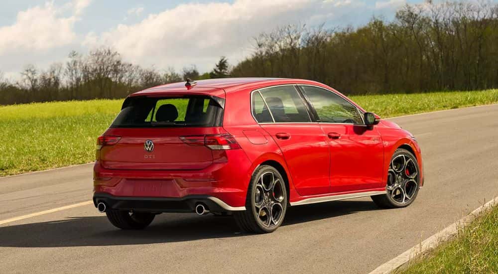 Red 2026 Volkswagen Golf GTI rear view driving down the road