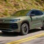 Olive Green 2026 Volkswagen Tiguan driving on the road.