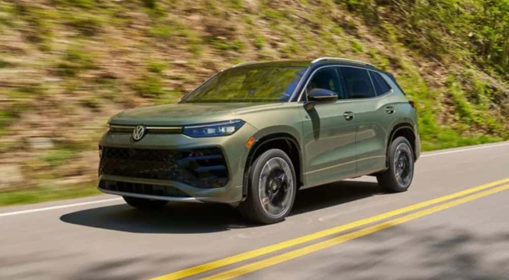 Olive Green 2026 Volkswagen Tiguan driving on the road.