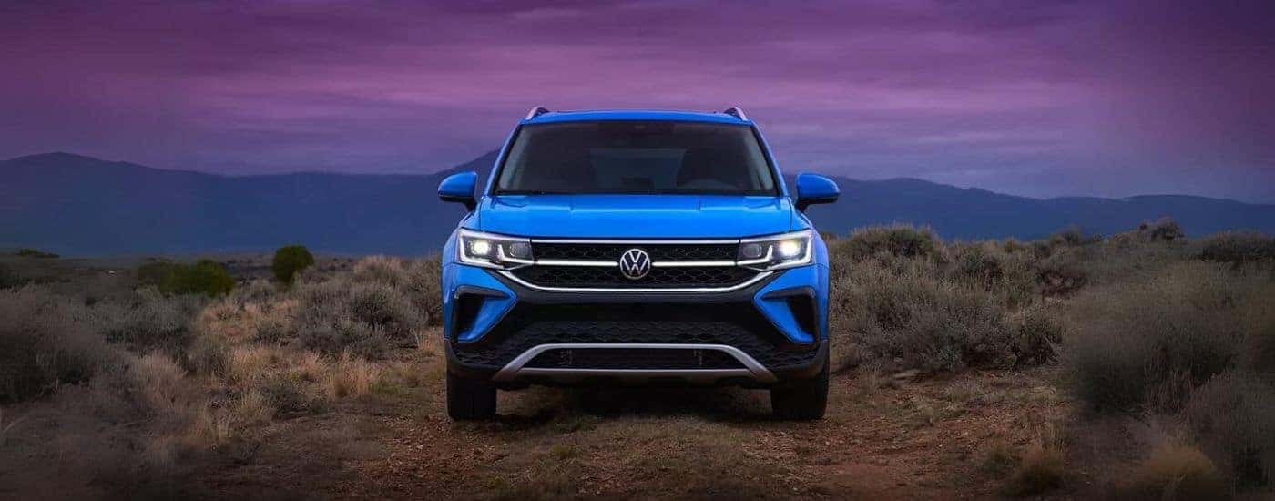 A 2024 Volkswagen Taos parked by a purple sunset.
