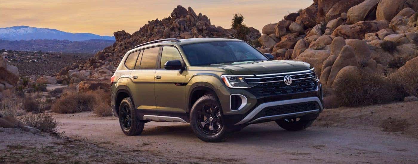 A 2026 Atlas SE Peak Edition with 4MOTION® shown in Avocado Green driving a dirt trail.