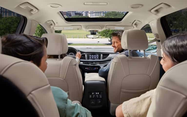 An interior picture taken from the rear of an SUV with a family inside.