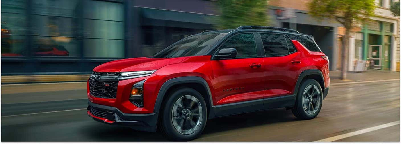 Red 2026 Chevrolet Equinox RS driving down a city street.
