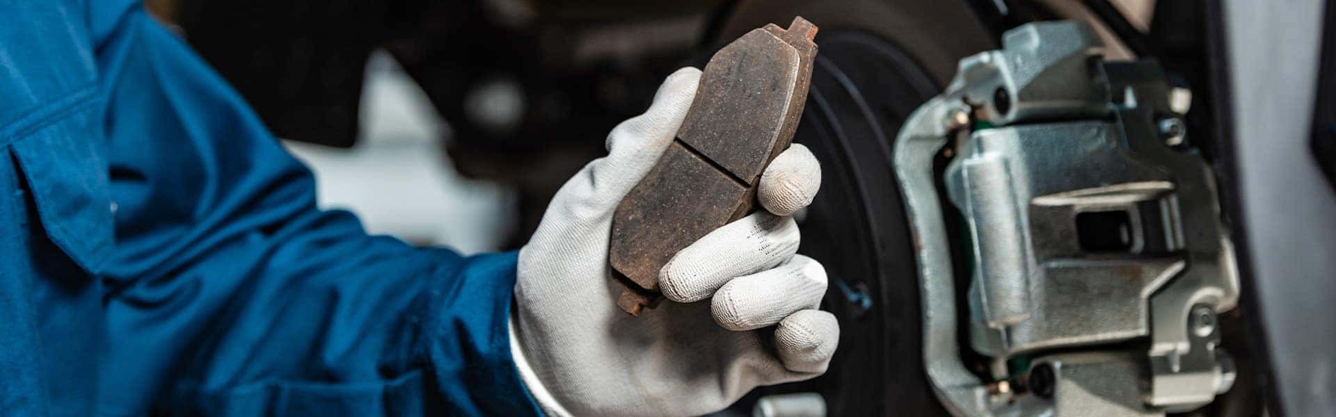 Brake replacement and Safety at Jack Giambalvo Buick-GMC | Service Advisor Holding Brake Pad