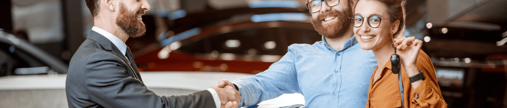 Vehicle Registration Taxes and Fees at Jack Giambalvo Buick GMC in York, PA | Couple smiling and shaking hands with sales person on the left because they bought a new car