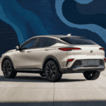A rearside view of a silver Buick Envista in front of a mural.