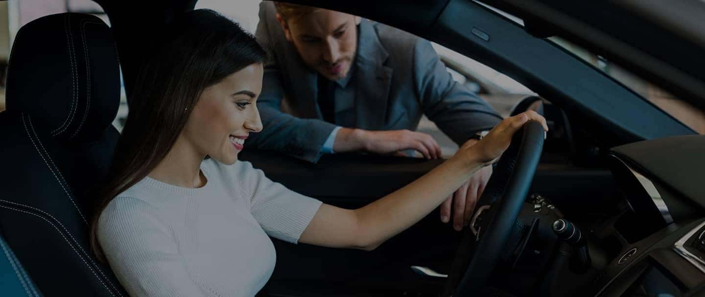 Woman in drivers seat talking to man outside of car