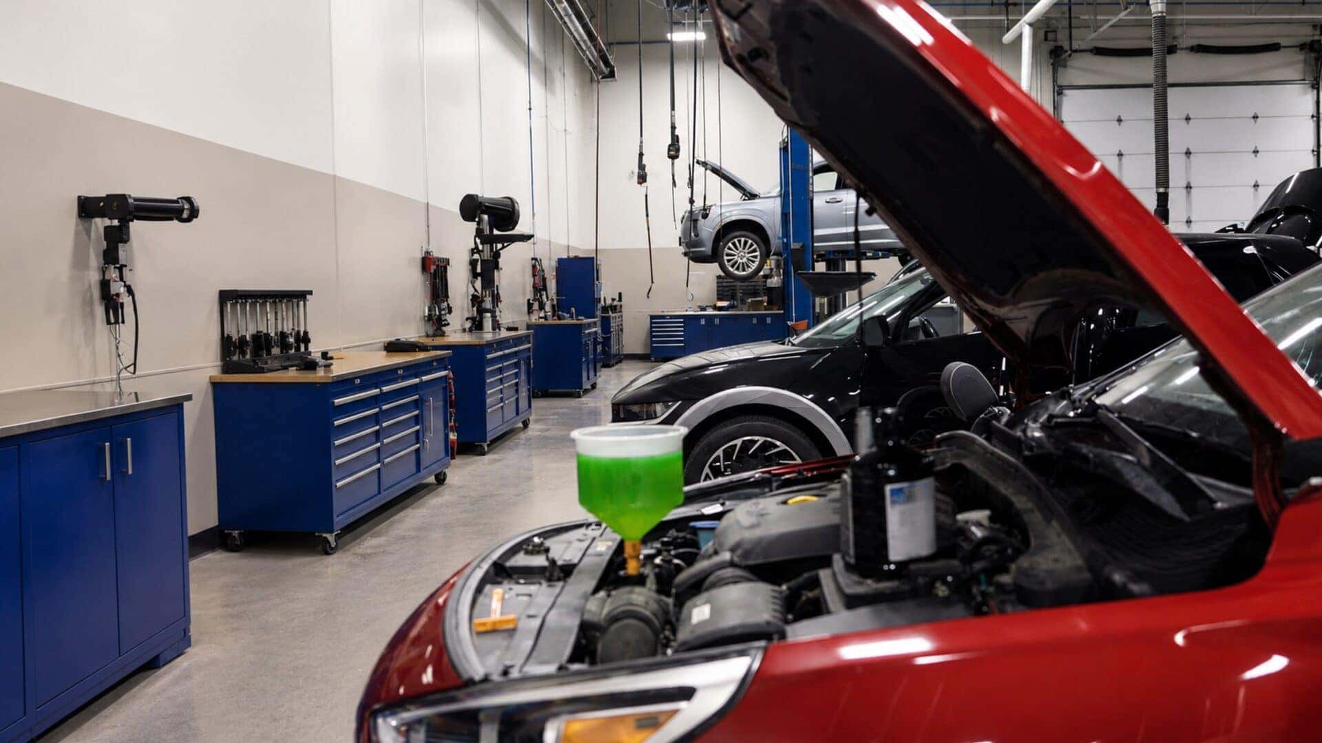 Hyundai technician performing undercar service on a vehicle raised on a lift