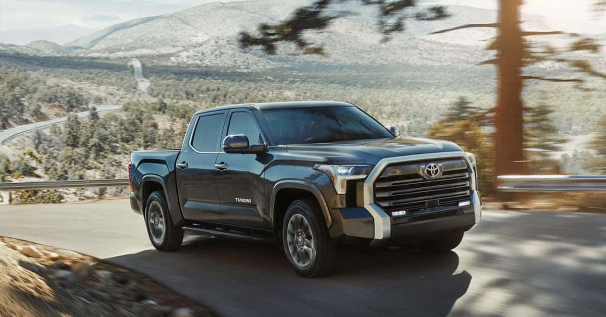 2026 Toyota Tundra full-size pickup truck driving along a winding mountain road.
