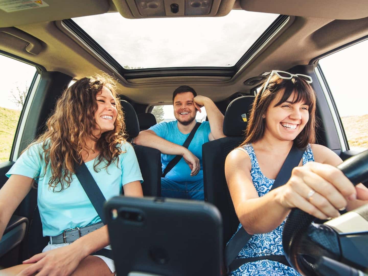 3 friends smiling and having a great time on a road trip