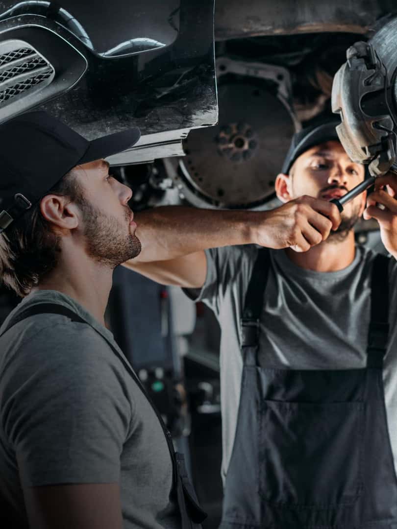 Service technicians working underneath vehicle