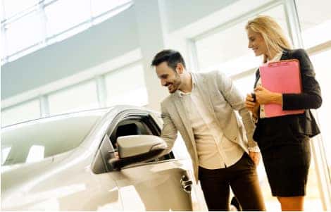 Guy in suit checking out Car with Saleswoman