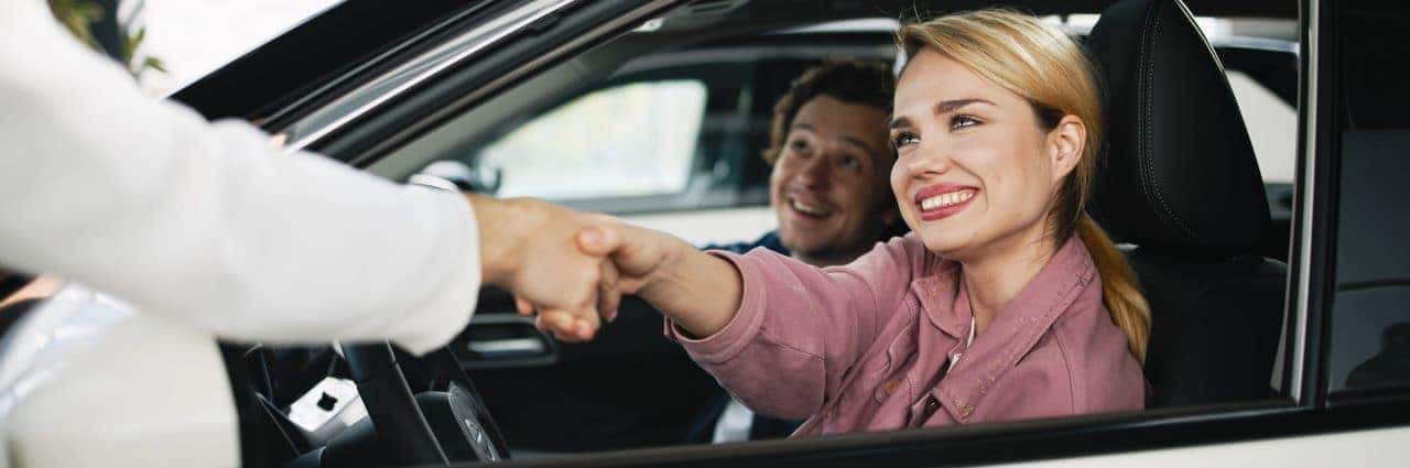 A happy customer driving away in a newly purchased used vehicle at T's Auto & Truck Sales, emphasizing great deals and quality service.