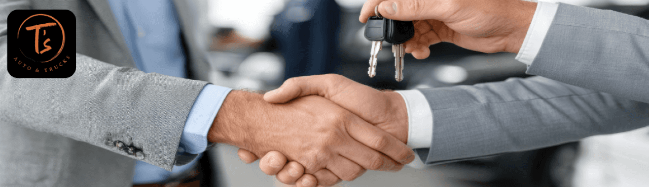 Customer handing over car keys to a representative at T’s Auto & Truck Sales in Omaha, NE.