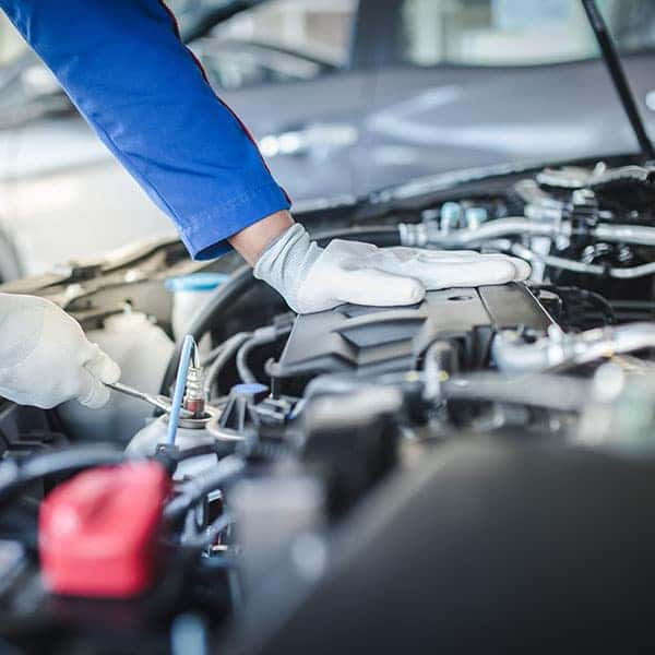 Cropped image of handsome mechanic in uniform is working in auto